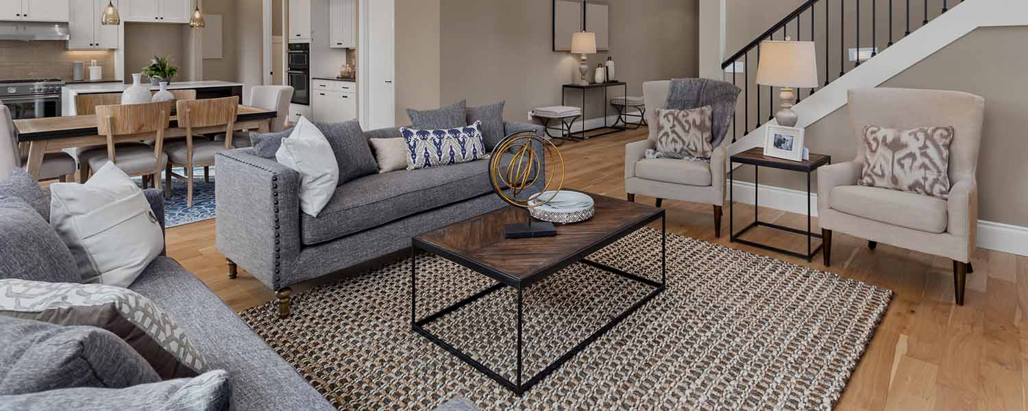 Beautiful living room interior with hardwood floors and and view of kitchen in new luxury home